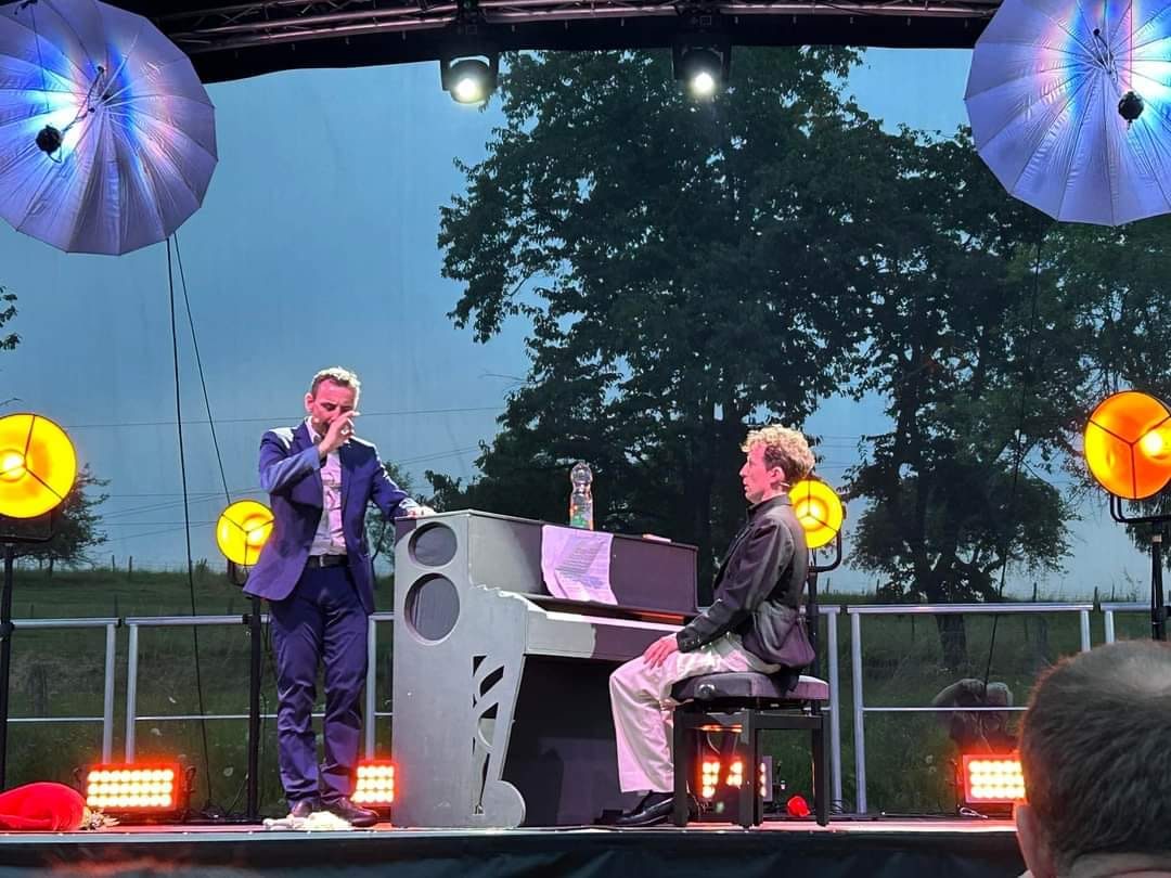 Gaël Dubreuil, en costume bleu, face à Pierre Mer assis au piano