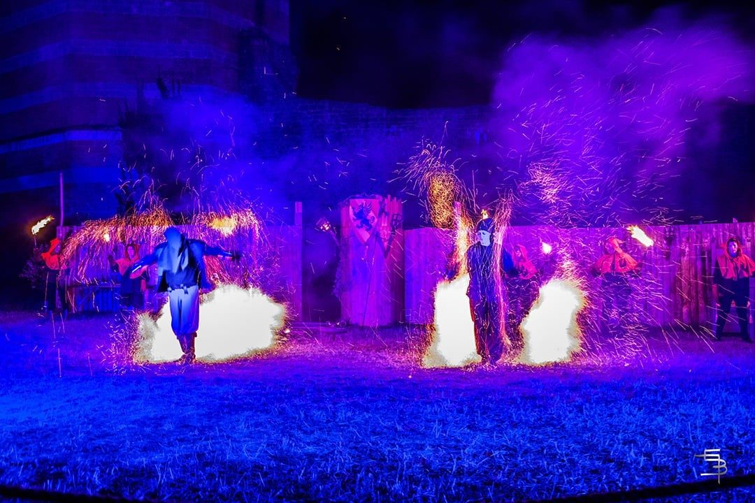Gerbes d'étincelles et lumières violettes devant les palissades du château