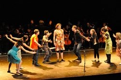 Les comédiens en scène devant l'orchestre